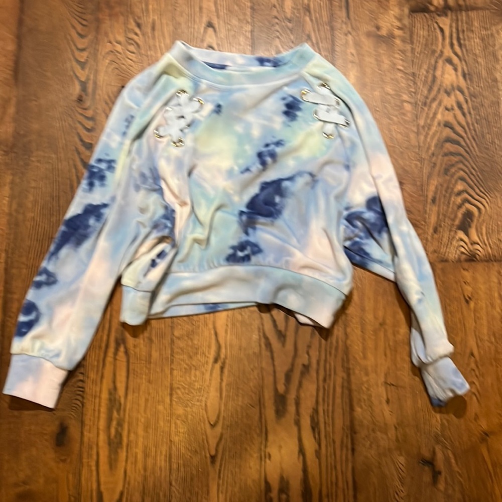 A blue sweater with string crosses in the front